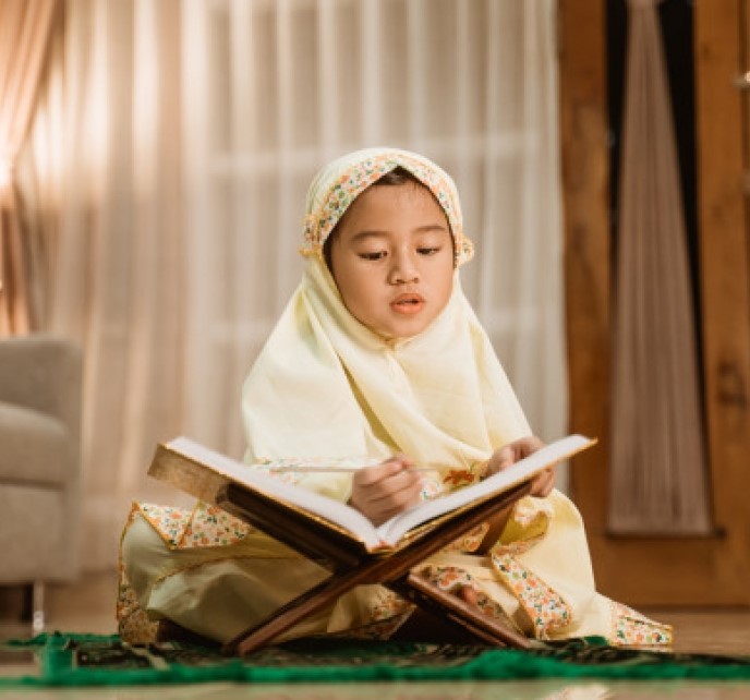 A young girl reading the Quran at home